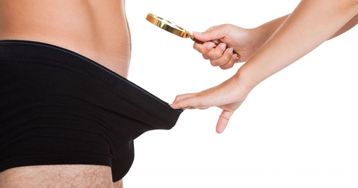 Een meisje kijkt door een vergrootglas naar een kleine penis